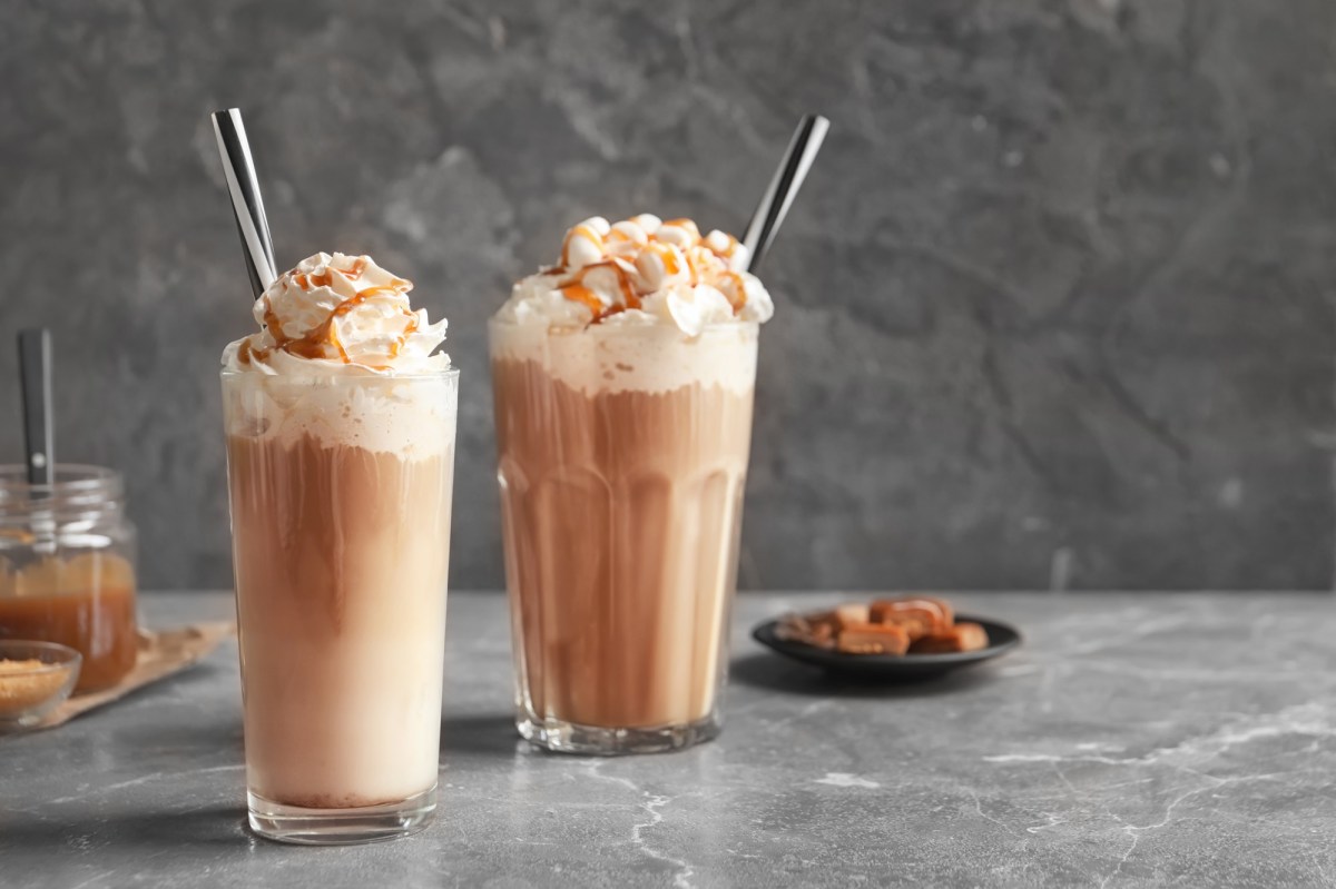 2 Gläser Salted Caramel Latte mit Schlagsahne, im Hintergrund Karamellbonbons.