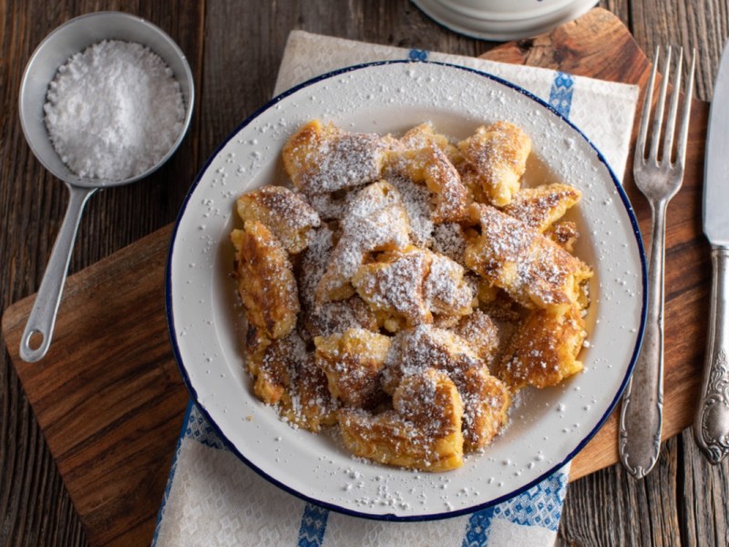 Veganer Kaiserschmarrn mit Puderzucker uaf einem Teller ind er Draufsicht.