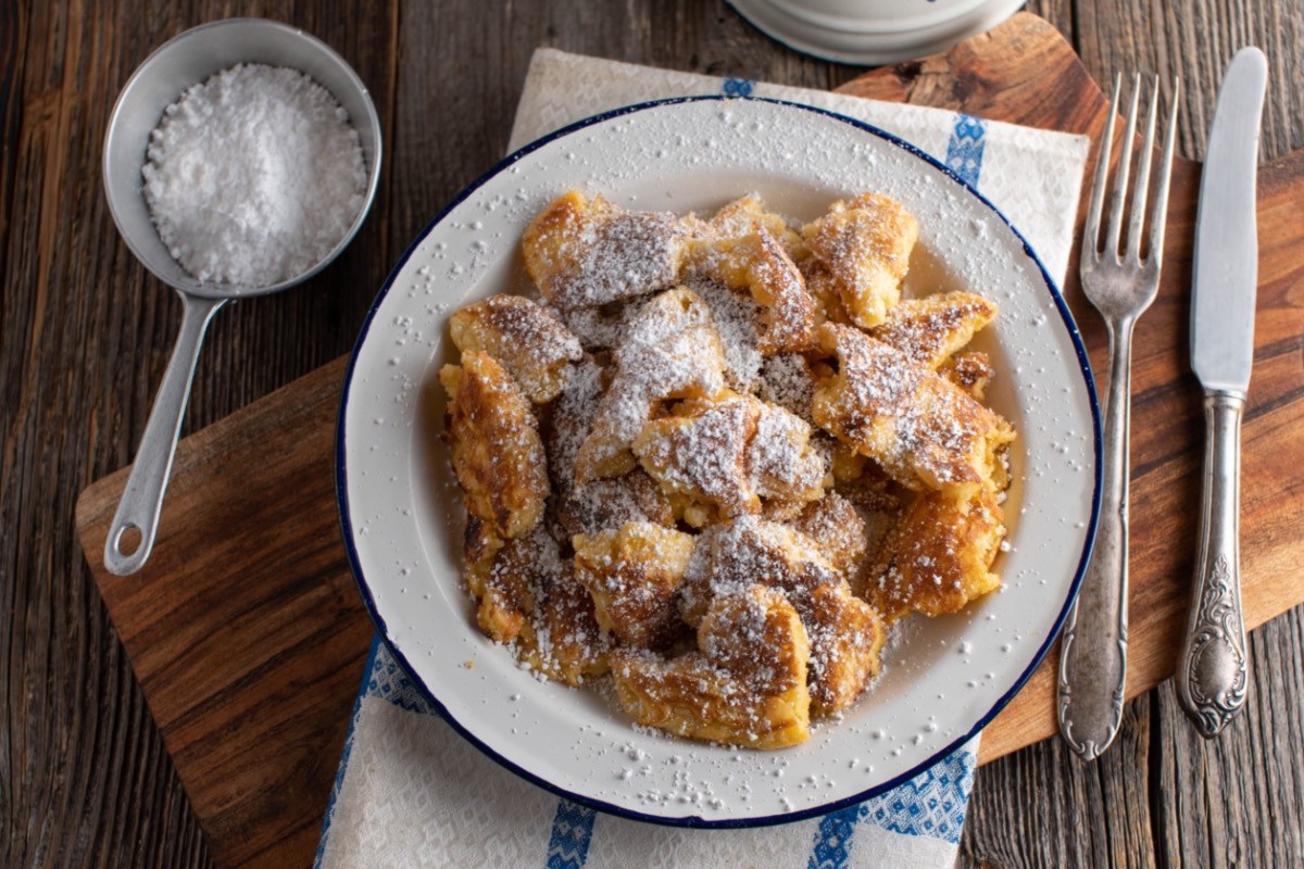 Veganer Kaiserschmarrn mit Puderzucker uaf einem Teller ind er Draufsicht.