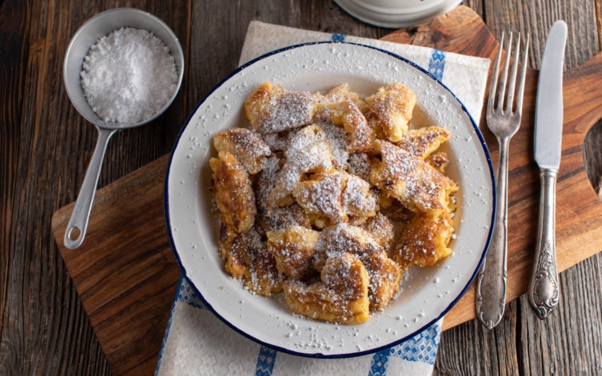 Veganer Kaiserschmarrn mit Puderzucker uaf einem Teller ind er Draufsicht.