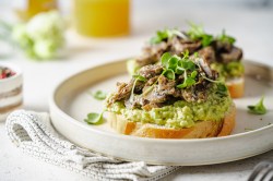 Avocado-Toast mit gegrillten Champignons auf einem Teller