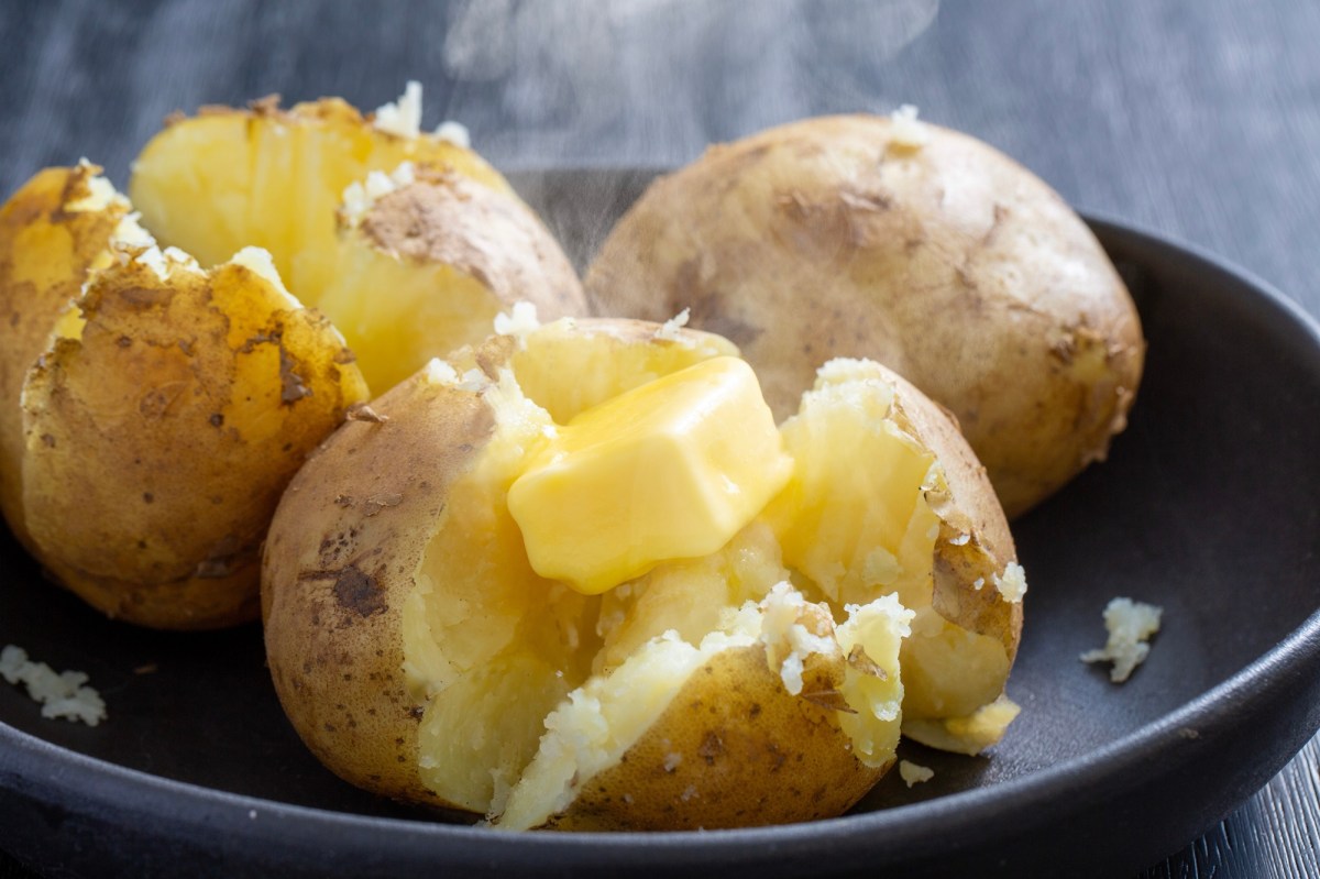 Mehligkochende Kartoffeln nach dem Kochen, aufgeschnitten und mit Butter garniert.