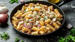 Nudel-Hackfleisch-Pfanne mit Feta auf einem Tisch