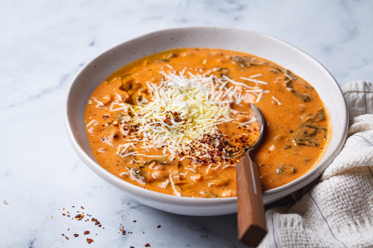 Eine Schüssel mit Tomaten-Bohnen-Suppe, bestreut mit Parmesan.